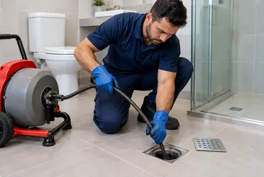 Profissional realizando o desentupimento de um ralo com ferramentas especializadas.